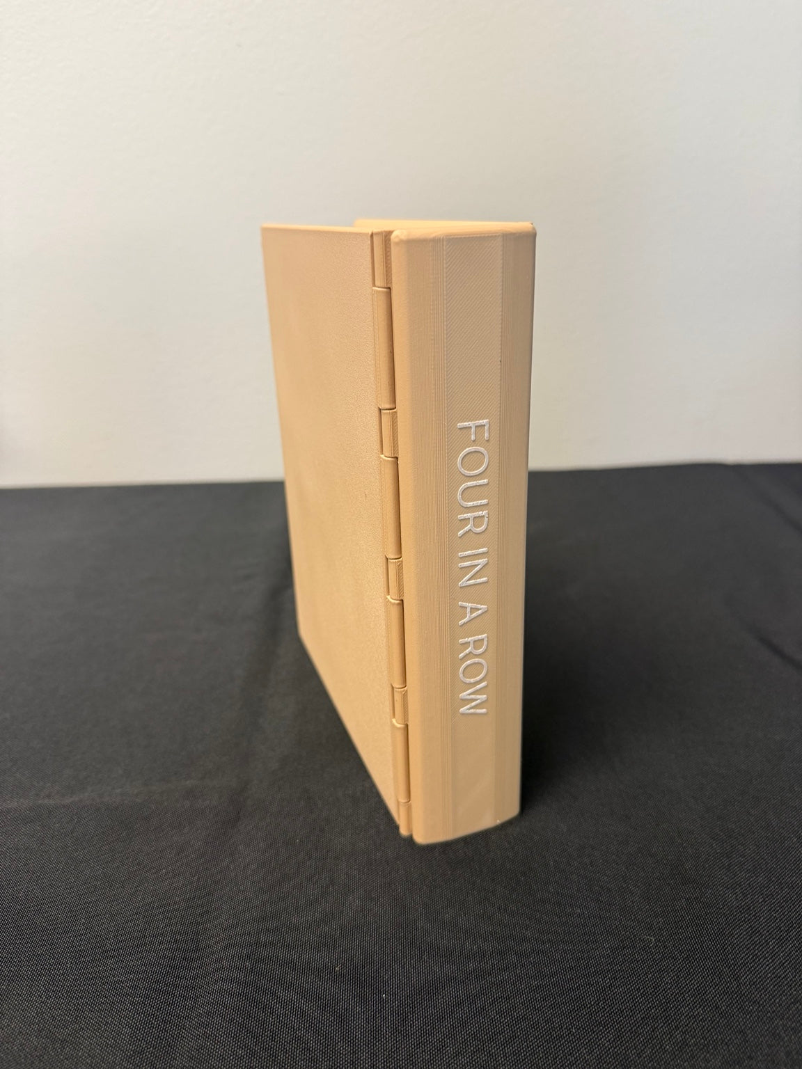 Closed cream-colored Four in a Row book case