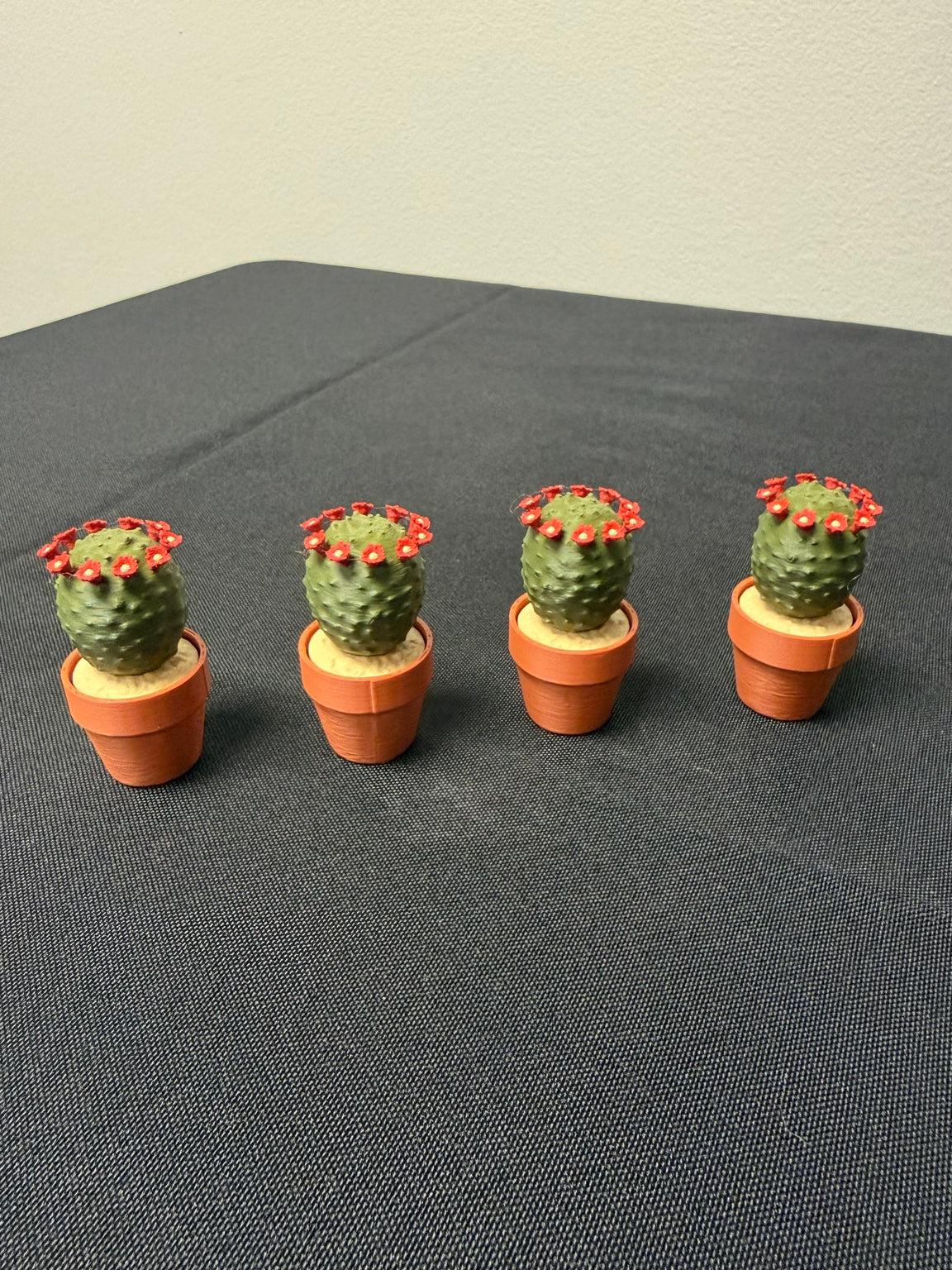 Flowering Barrel Cactus clickers with red flowers in orange pots