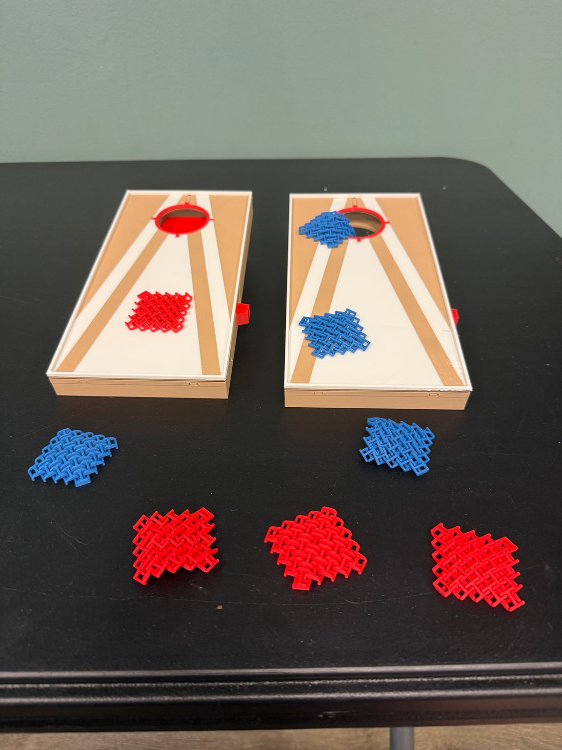Mini tabletop cornhole boards with red and blue playing pieces