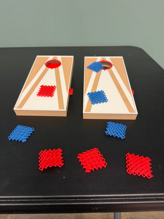 Mini tabletop cornhole boards with red and blue playing pieces