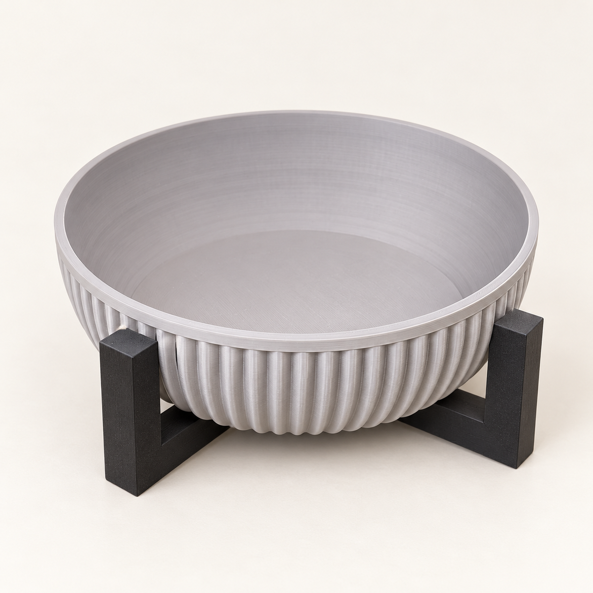 Light gray ribbed Alder bowl on a dark geometric stand