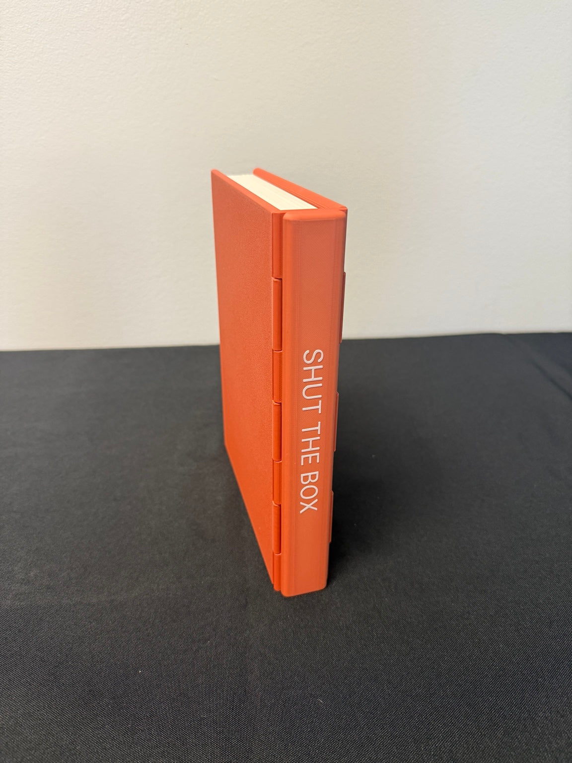 Closed orange Shut the Box book case