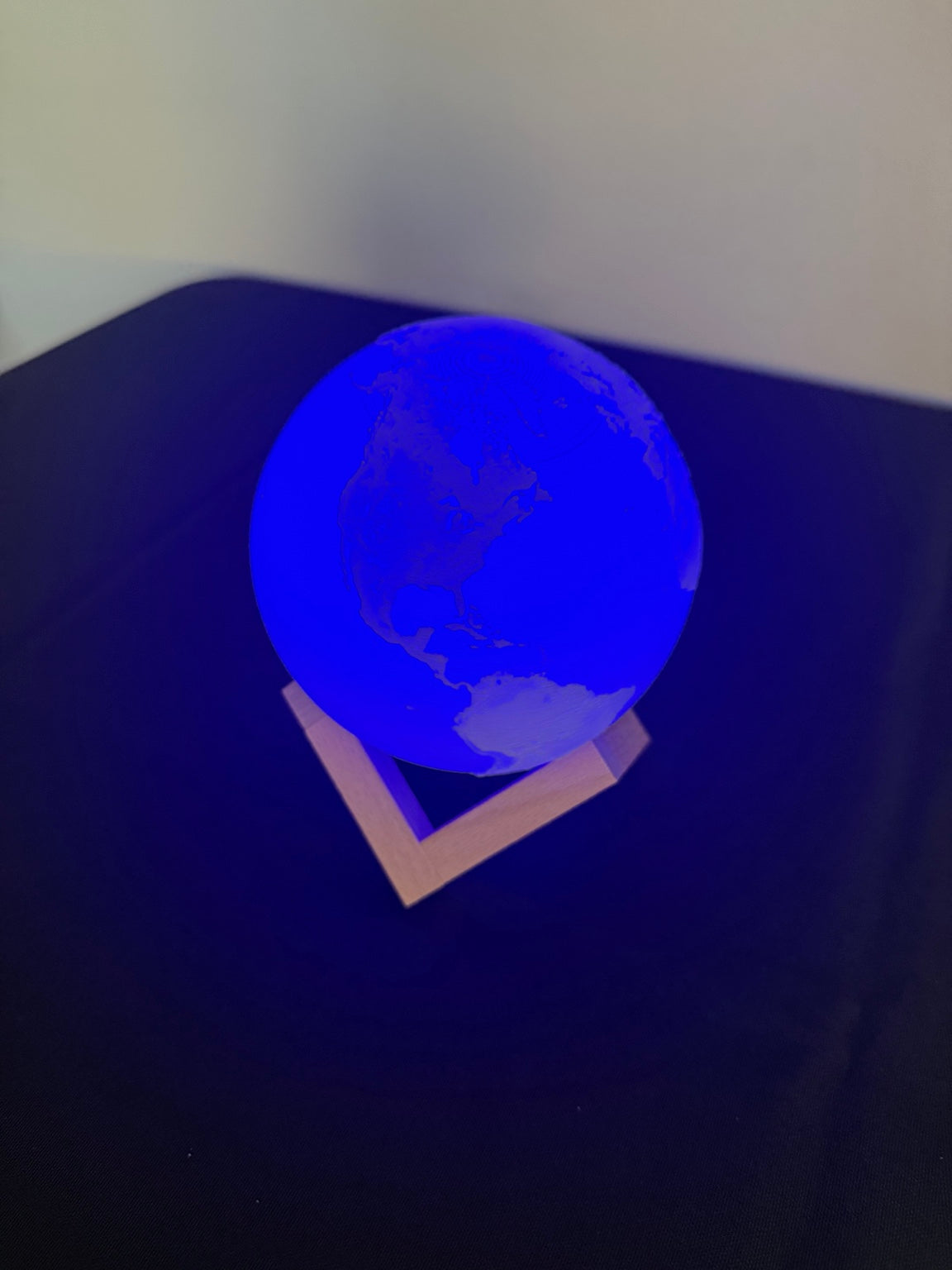 Globe light illuminated blue on its triangular stand