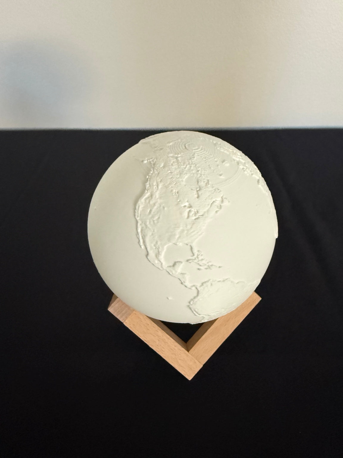 Globe light showing textured continents and its stand