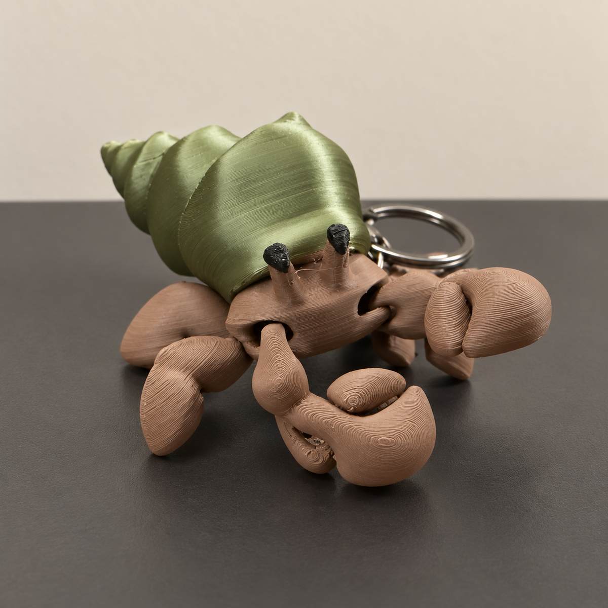 Articulated hermit crab keychain with green shell