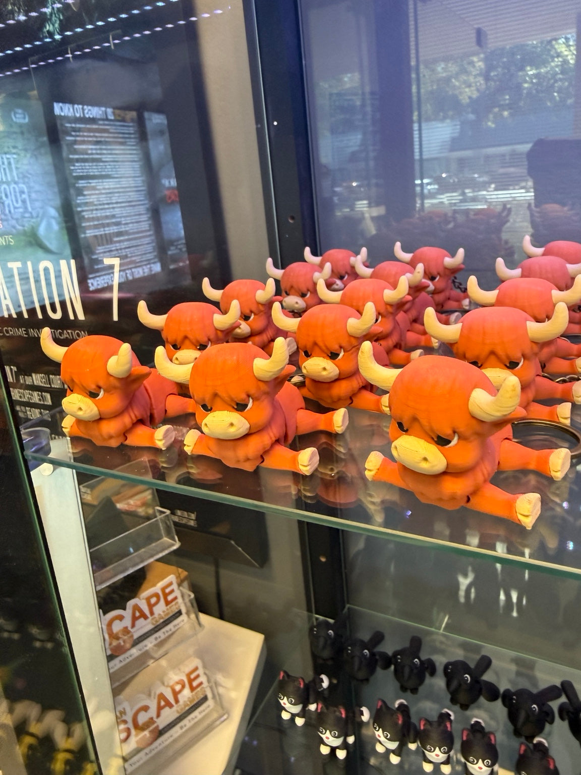 Highland cow keychain examples displayed on a glass shelf