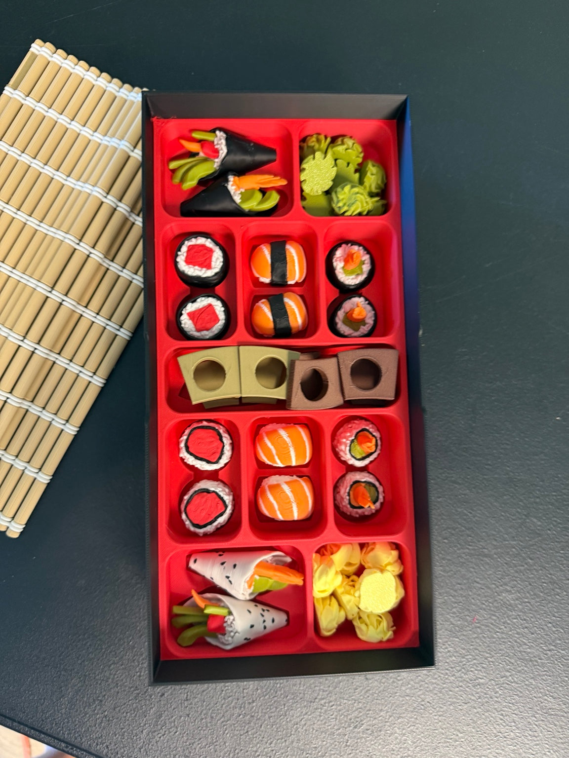 Sushi chess pieces organized inside the red storage tray