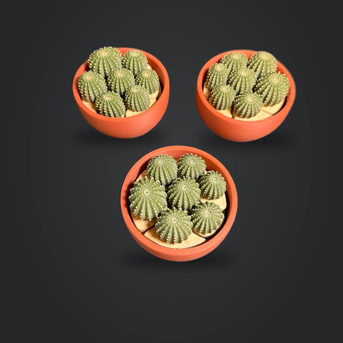 Three orange cactus cluster fidget bowls photographed from above