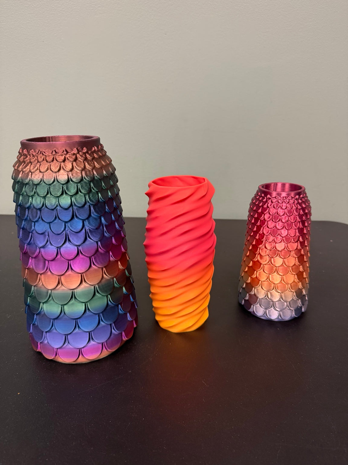 Three 3D-printed vases with scale and spiral patterns